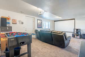 Carpeted cinema room with a textured ceiling