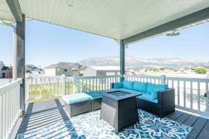 Deck with an outdoor living space with a fire pit and a mountain view