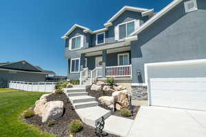 Craftsman-style home with a garage, a front yard, and covered porch