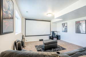 Carpeted cinema room with a textured ceiling