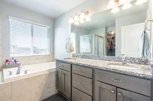 Bathroom featuring independent shower and bath and double sink vanity