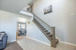 Staircase featuring light tile patterned floors