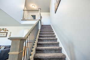 Stairway featuring a towering ceiling