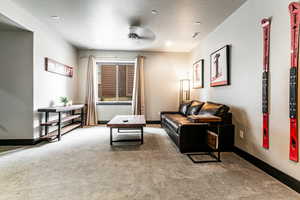 Living room with a textured ceiling, carpet, and ceiling fan