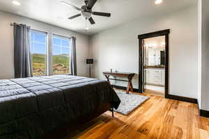 Tiled bedroom with ceiling fan and ensuite bath