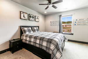 Carpeted bedroom featuring ceiling fan