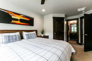 Bedroom with carpet flooring, connected bathroom, and ceiling fan