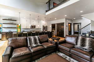 Living room with a high ceiling and hardwood / wood-style flooring