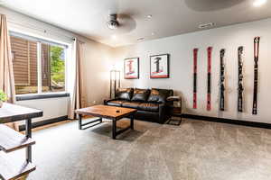 Carpeted living room with a textured ceiling and ceiling fan