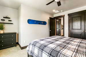 Bedroom featuring light carpet, a closet, and ceiling fan