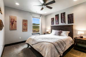 Carpeted bedroom with ceiling fan and a textured ceiling