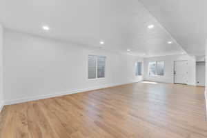 Unfurnished living room featuring a textured ceiling and light hardwood / wood-style floors