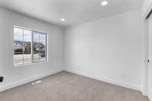 Unfurnished room with a textured ceiling and carpet