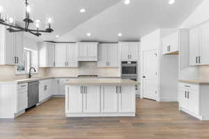 Kitchen featuring a chandelier, stainless steel appliances, light hardwood / wood-style floors, and white cabinetry