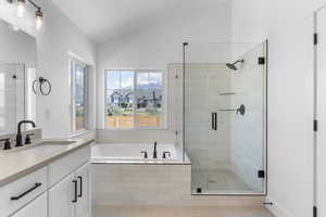 Bathroom with vanity, vaulted ceiling, tile patterned floors, and separate shower and tub