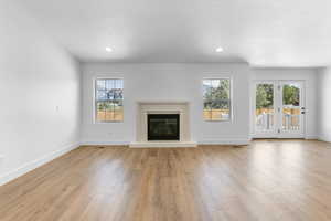 Unfurnished living room with a textured ceiling and light wood-type flooring