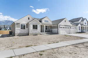 View of front of property featuring a garage and central air condition unit