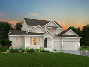 View of front of house featuring a garage and a yard