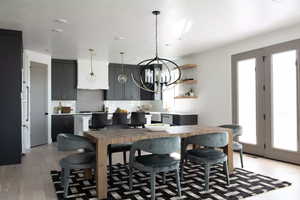 Dining space featuring a healthy amount of sunlight, an inviting chandelier, and light wood-type flooring