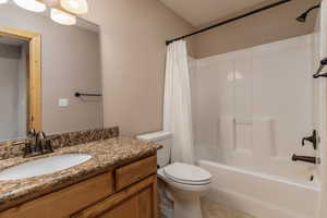 Full bathroom with shower / bathtub combination with curtain, tile flooring, vanity, and toilet
