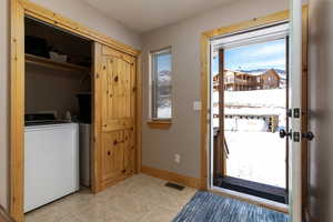 Entryway with plenty of natural light, light tile floors, and washing machine and clothes dryer