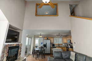Living room featuring hardwood / wood-style flooring, a stone fireplace, sink, track lighting, and ceiling fan