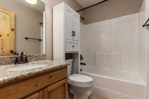 Full bathroom with bathtub / shower combination, tile flooring, toilet, and vanity