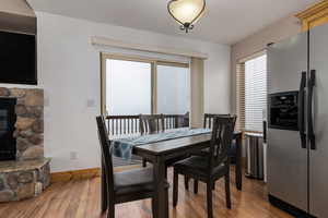 Dining area featuring a stone fireplace and hardwood / wood-style floors