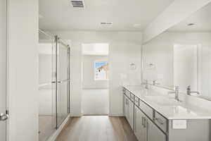 Bathroom with walk in shower, hardwood / wood-style floors, and dual bowl vanity