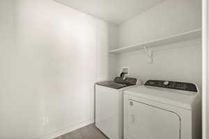 Laundry room featuring washing machine and dryer and hardwood / wood-style flooring