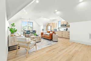 Accessory Apartment Living room with light hardwood / wood-style flooring and lofted ceiling, kitchen.