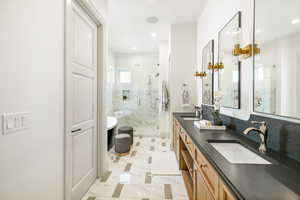 Primary Bathroom with tile floors, a shower with door, and dual bowl vanity