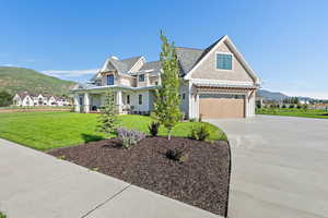 Craftsman-style home featuring a mountain view, a garage, and a front lawn