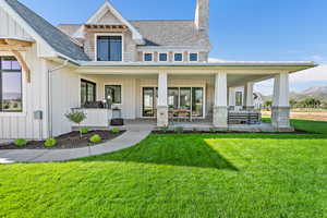 Rear view of house with a lawn and covered porch