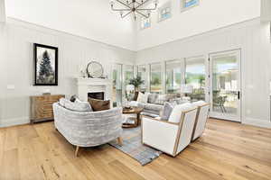 Living room with plenty of natural light, light hardwood / wood-style floors, and an inviting chandelier