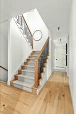 Stairway with light wood-type flooring leading to 2nd level