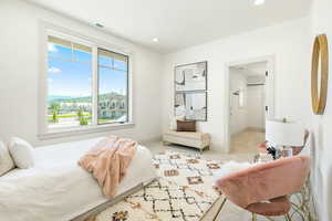 Bedroom featuring light colored carpet and multiple windows