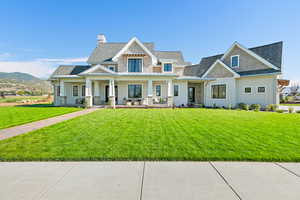 View of front of property featuring a mountain view, a front yard, and a porch