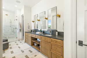 Primary Bathroom with backsplash, dual bowl vanity, tile flooring, and an enclosed shower