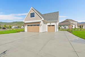 View of front of house with a garage, a mountain view, and a front yard