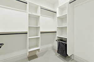 Spacious closet featuring light colored carpet