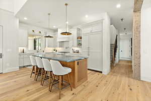 Kitchen featuring a kitchen breakfast bar, white cabinets, light hardwood / wood-style floors, and a kitchen island