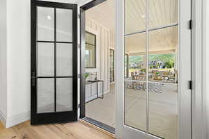 Doorway from Primary Suite  to outside  covered patio with light hardwood / wood-style floors