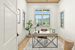 Office area with wooden ceiling, parquet flooring, and a mountain view