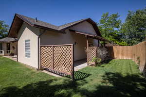 Rear view of property with a yard and a patio