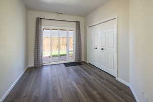 Unfurnished bedroom with dark hardwood / wood-style flooring, a closet, and access to outside