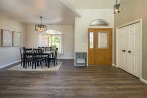 Entryway with an inviting chandelier and dark hardwood / wood-style flooring