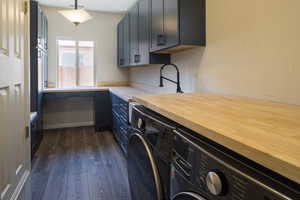 Washroom featuring washer and dryer, cabinets, sink, and dark hardwood / wood-style flooring