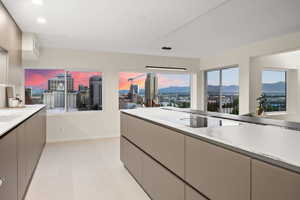 Kitchen with gray cabinetry, hanging light fixtures, electric cooktop, and light tile floors