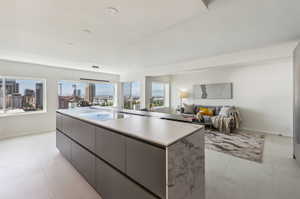 Kitchen with decorative light fixtures, light tile floors, and a kitchen island